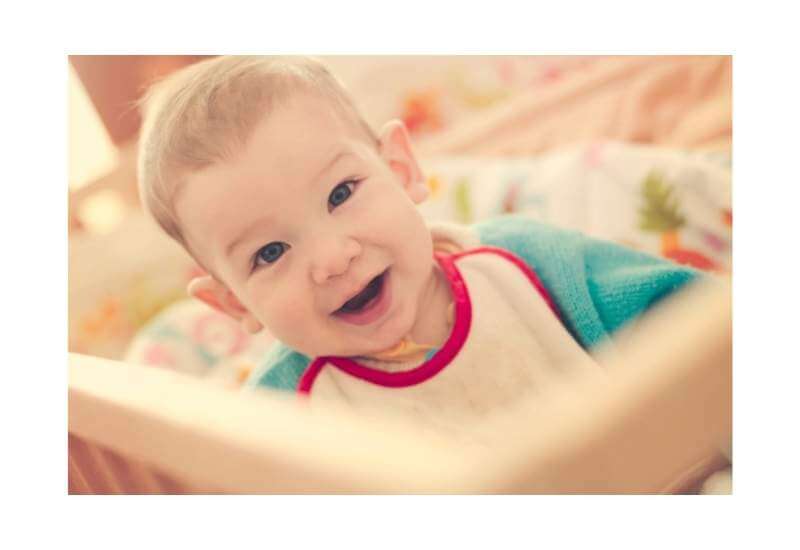 Baby smiling at a crib